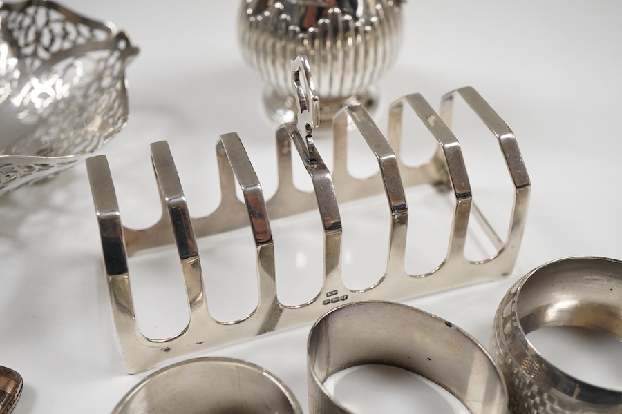 Sundry small silver including an Edwardian oval tea caddy, Hasseler Brothers, London, 1901, 10.4cm, a pierced bonbon dish, a late Victorian cream jug, five napkin rings including two pairs, a seven bar toast rack, a dama